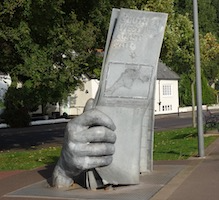 the statue of a hand holding a map which marks the beginning of the South West Coast Path